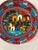 Vibrantly colorful pair of hand-painted pottery plates each depicting a folk community scene. Excellent condition. Holes...