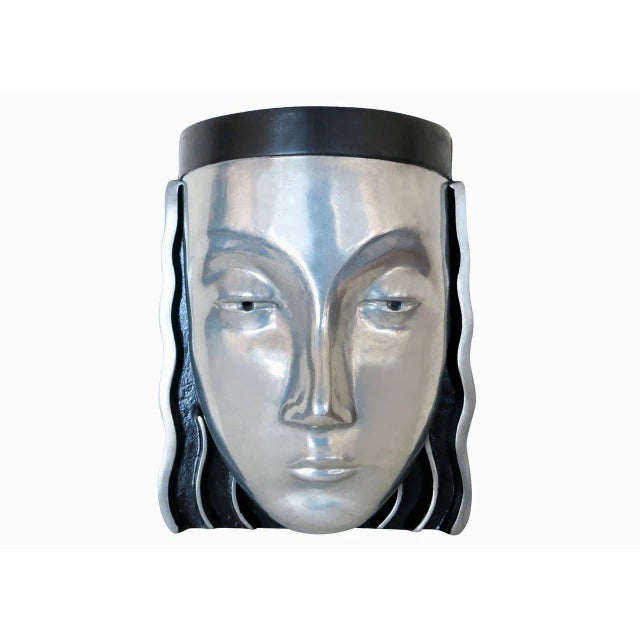 A pair of Art Deco styled female face mask wall sconces with a signature on the back marked“118 P. " The wall sconces...