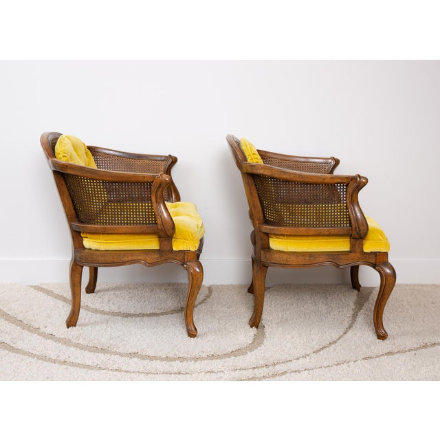 Mid-century curved cane back Hollywood Regency, French Provincial barrel chairs. Plush gold tufted velvet seat and...