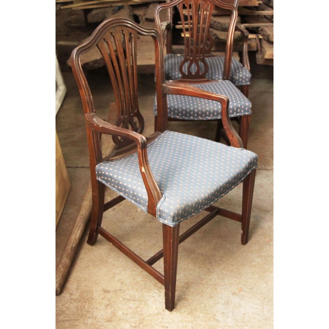 Vintage medium toned wood armchair with the shield-back silhouette originally popularized during the Neoclassical era by...