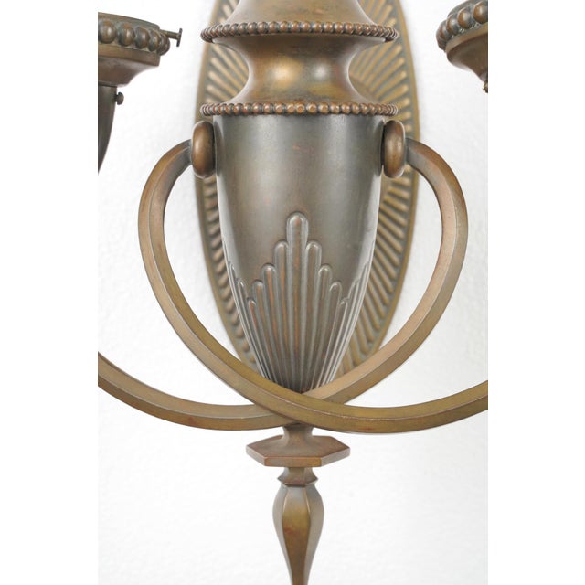Art Deco style wall sconces made of solid bronze, each with two arms. Stamped Bradley & Hubbard. Each sconce requires two...