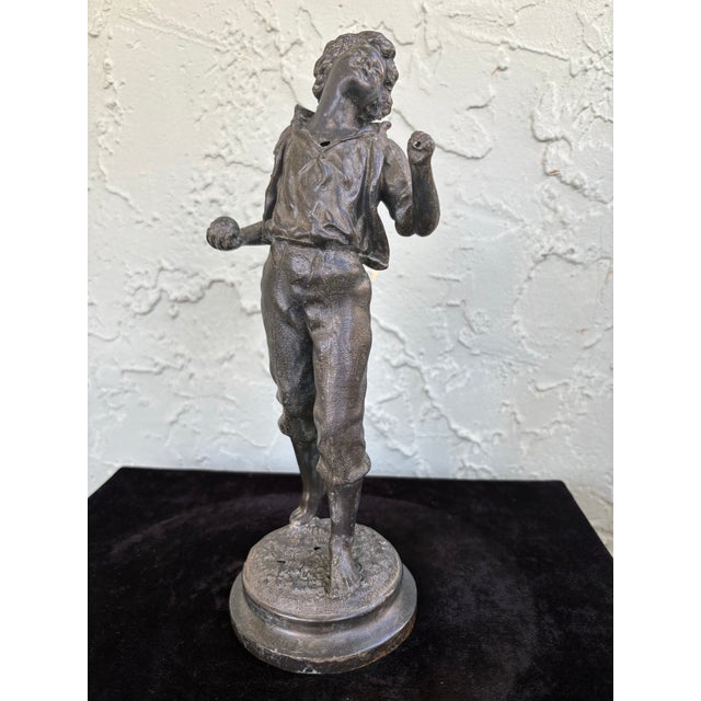 This evocative antique sculpture depicts a young boy captured in a moment of emotional intensity, his head tilted back and...