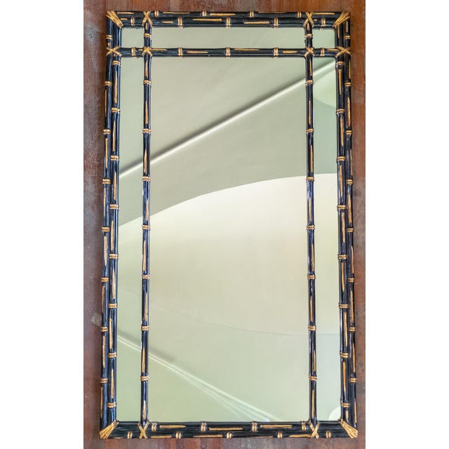 We are selling this 20th century decorative Chinoiserie style mirror. This mirror has black and gold painted faux bamboo...