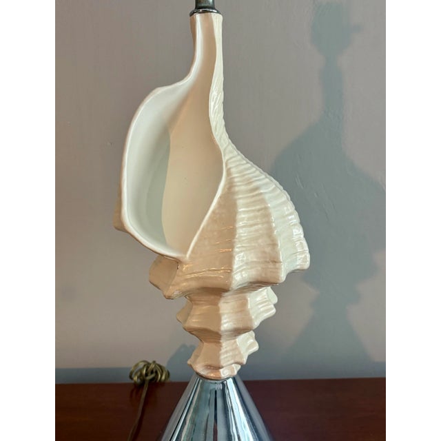Vintage coastal style conch shell lamp. Blending elements of mid century modern with Hollywood regency to create a simple...