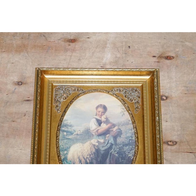 A charming vintage Victorian-style print titled “Young Shepherdess”, presented in an elegant gilded frame that beautifully...