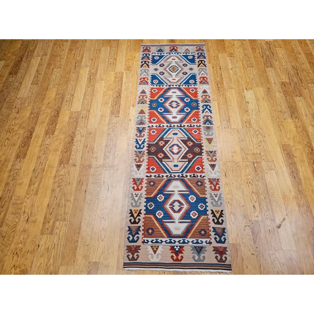 The compelling artistry of Anatolian weaving with this exceptional Vintage Turkish Kilim Runner, meticulously handwoven in...