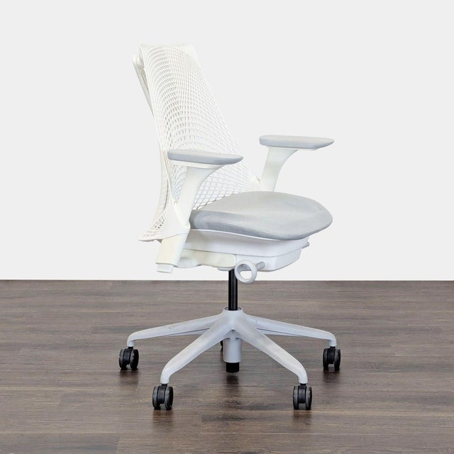 This Herman Miller office chair features a modern white design with a flexible mesh back for comfort and support. It has...