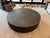 This is a Restoration Hardware round coffee table featuring a sleek black finish and subtle brass trim for a modern touch....