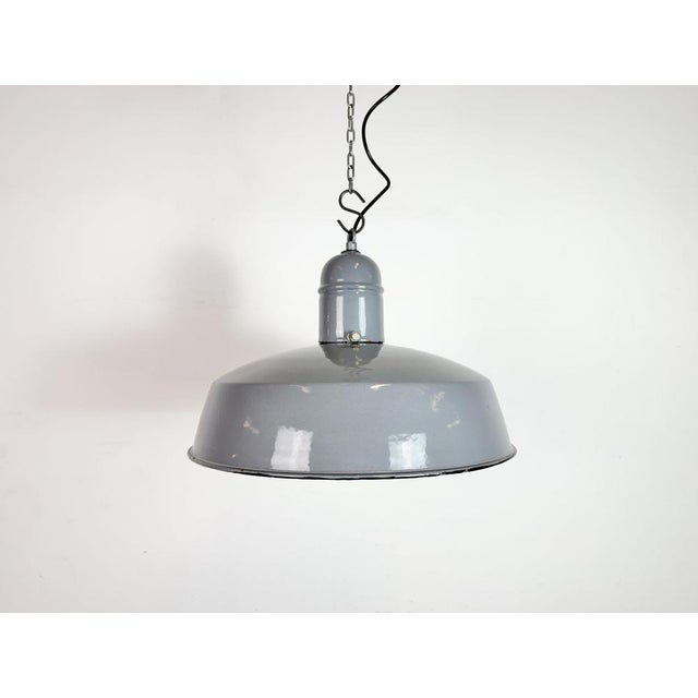 Industrial grey enamel factory pendant light made in Netherlands during the 1960s. White enamel inside the shade. Iron...