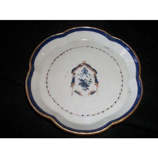 Antique early 19th c. Chinese export porcelain tea pot stand. Decorated with a stylized crest and bright blue border...