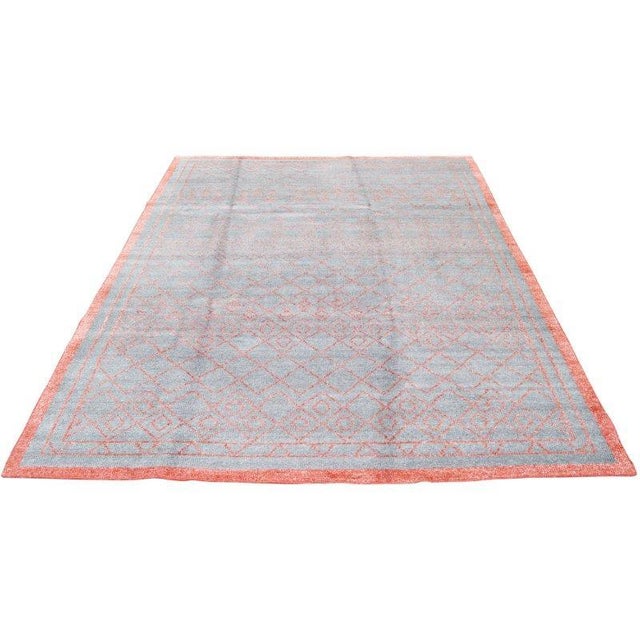 A hand-knotted Moroccan rug featuring diamond and linear motifs in cerulean and orange shades. Its texture and precise...