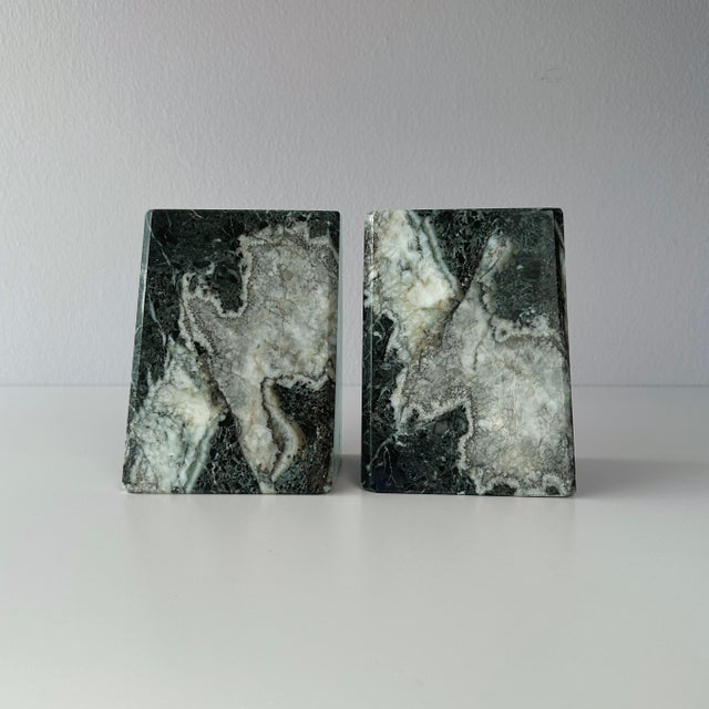 Late 20th century carved and polished green marble stone bookends. These slanted bookends have large white veining...
