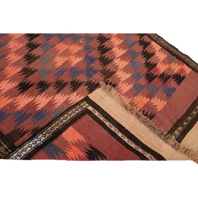 Beautiful vintage Turkish Kilim hand-knotted wool rug with a peach field. This piece has a brown frame and multicolor...