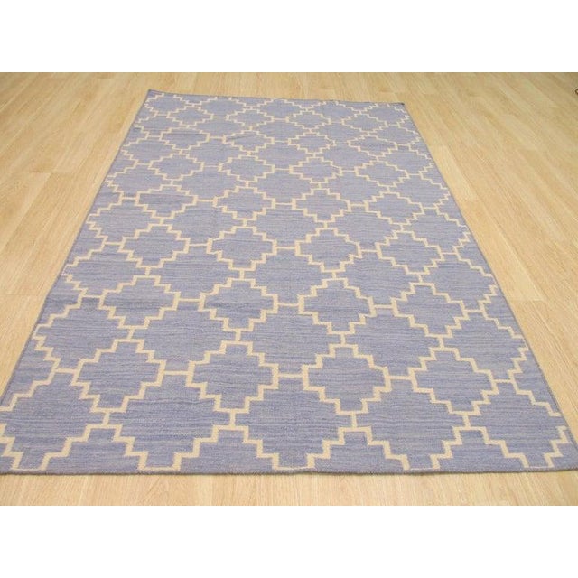 This blue wool rug features a flat weave construction and reflects the traditional kilim style. Handcrafted in India, the...