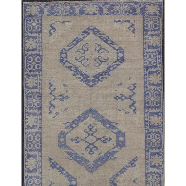 Measures: 4'6 x 12'6 This vintage Oushak gallery runner features blue medallions on a sandy-taupe field. The border and...