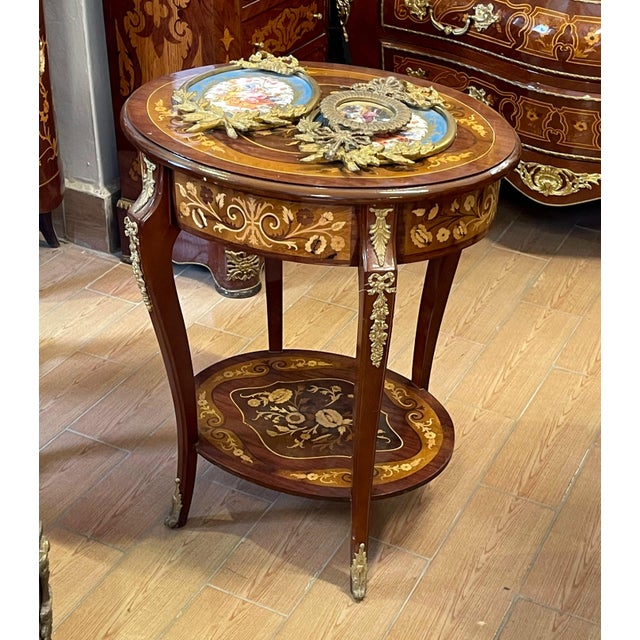 Bring timeless European elegance to your home with this French Louis XVI-inspired side table, featuring a rich reddish-...