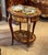 Bring timeless European elegance to your home with this French Louis XVI-inspired side table, featuring a rich reddish-...