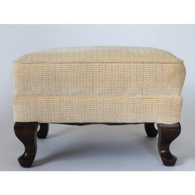 Vintage footstool or ottoman with ivory-colored, upholstered cushion and dark, curved wood legs. No makers mark. Some very...