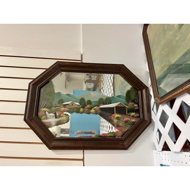 Mid Century wood framed wide octagon shaped mirror. The mirror has a oil painting Depicted is a covered bridge in the...