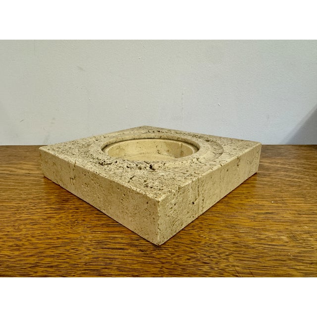 A square travertine bowl from the 1970s of Italian origin, epitomizing the era's affinity for natural materials and...