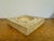 A square travertine bowl from the 1970s of Italian origin, epitomizing the era's affinity for natural materials and...