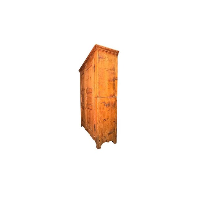 An impressive 19th-century fir wood wardrobe, constructed in two parts. The structure is embellished with a decorative...