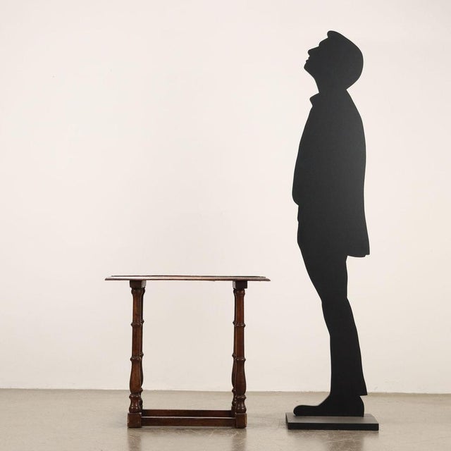 Walnut coffee table. Rectangular top with a beak-shaped molding, supported by four turned legs joined to the base by...