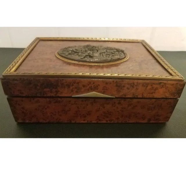 Beautiful burl walnut box. It was probably used as a cigarette case. Oval cast bronze plaque of a village celebration...