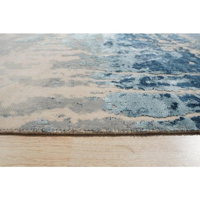 This machine-made area rug features a primary blue color palette and is constructed from wool. Manufactured in India, the...