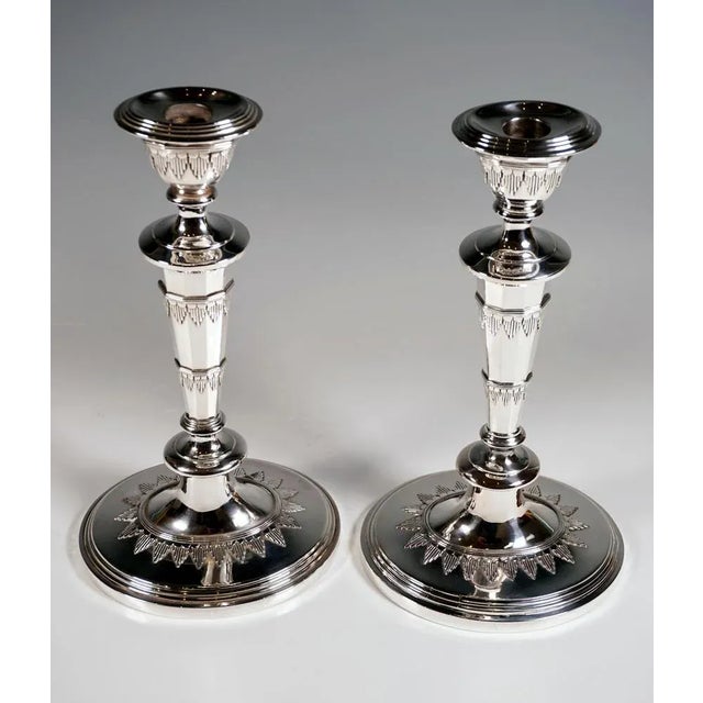 Pair of elegant silver candlesticks on a sweeping, oval base with stepped frame, at the foot of the shaft circumferential,...