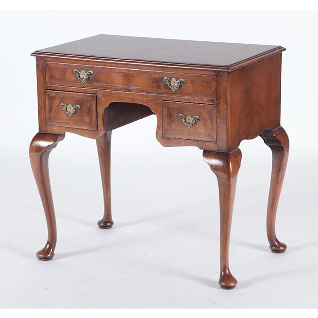 A 19th century English George I burl walnut dressing table with a rectangular top, molded edge, cross banded and satinwood...