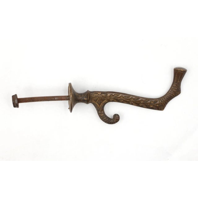 Antique hall tree hook with an elongated arm with an ornate design made from brass. Good condition with appropriate wear...