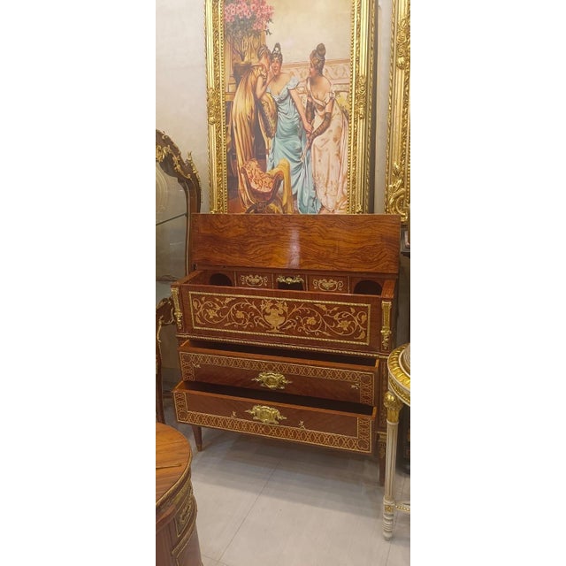 A truly exceptional French Louis XVIstyle secrétaire à abattant, crafted in rich mahogany and decorated with intricate...