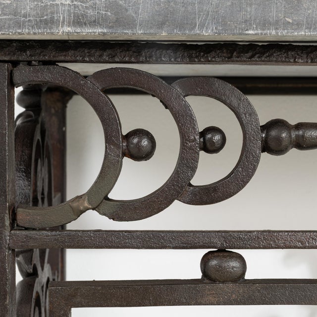 A circa 1860 French wrought iron console table with a Belgian bluestone top, executed in the neoclassical style. The...