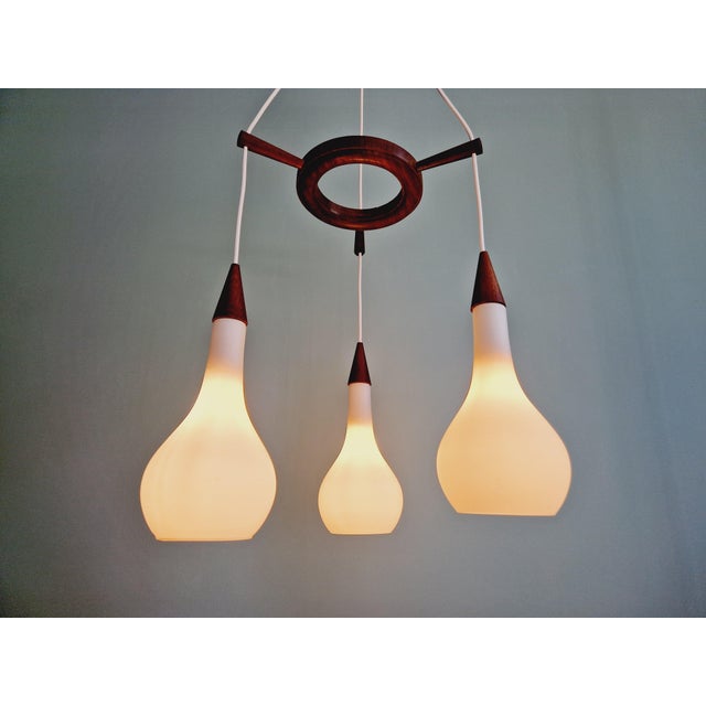 Scandinavian waterfall chandelier in teak and white satin glass from the 60s. Completely restored, it is in magnificent...