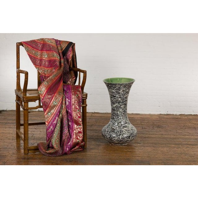 An artisan Prem Collection trumpet shaped vase with black ground, white dripping décor and green glazed interior. Charming...