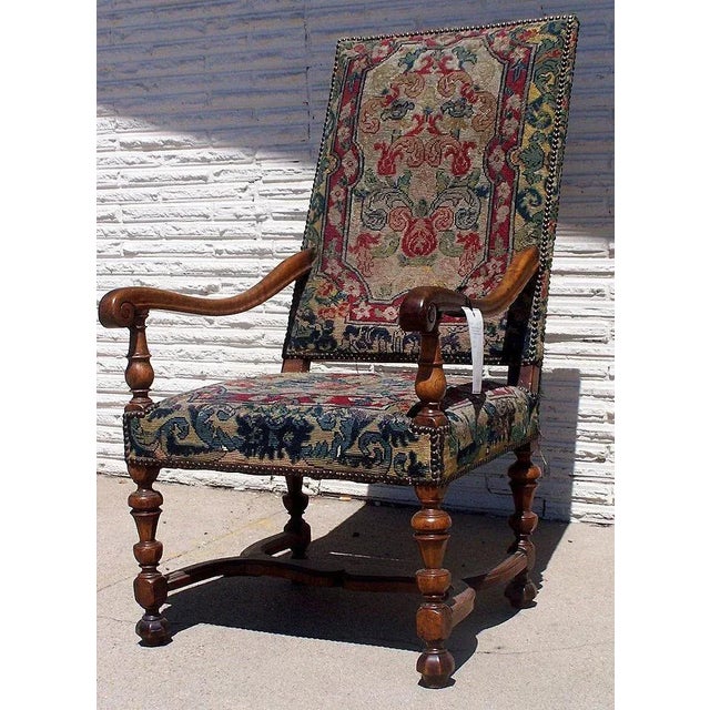French walnut Louis XIII arm chair. Rack back with os de mouton legs.Upholstered in period tapestry. 1700 24" x 31" x 42"