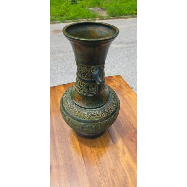 Stunning vintage bronze hu-form vase featuring dramatic elephant-head handles and intricate archaic Chinese taotie and...