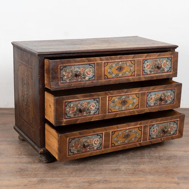 The soft earth tone colors are all original on this hand-painted antique chest of 3 drawers from Hungary. The lovely...