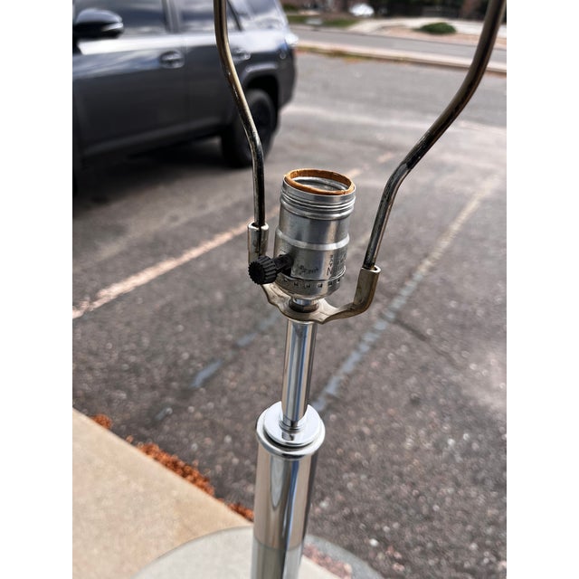 A striking mid-century modern floor lamp with an integrated circular glass table, featuring a sophisticated combination of...