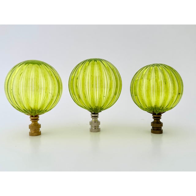 Oversized glass lamp finial crafted from a handblown glass bubble. Each has a vertical striped pattern and a ribbed...