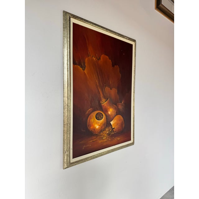 This captivating 1970s oil painting by Ankudowicz masterfully depicts a dramatic still life of golden-hued gourds and...