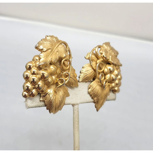 This is part of Chairish’s Costume Jewelry assortment. Goldtone die stamped "Danish grape leaf" 3d grape cluster with...