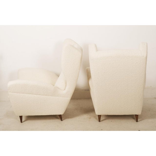 Pair of lounge or wingback chairs in cream DEDAR bouclé by Melchiorre Bega from the 1950. Chairs ware fully restored with...