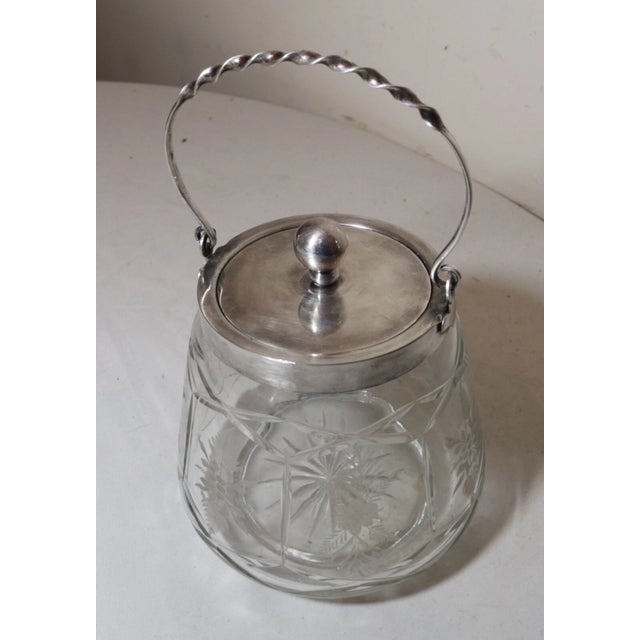 Up for sale is a nice quality antique nickel silver plated biscuit jar. The crystal jar is wheel cut with nice floral...