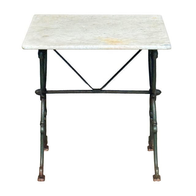 A fine French bistro table from the Belle Époque era, featuring a square figured white marble top, resting upon a...