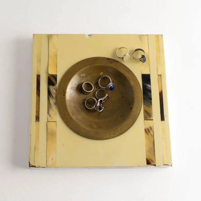 Vintage square catchall featuring a round brass ashtray inset at center, framed by rich tan, brown, and off-white horn...