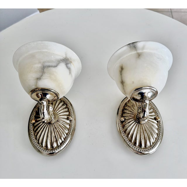 Pair nickel silver metal wall sconces with alabaster globe shades and sunburst motif backplates. Newly wired for US...