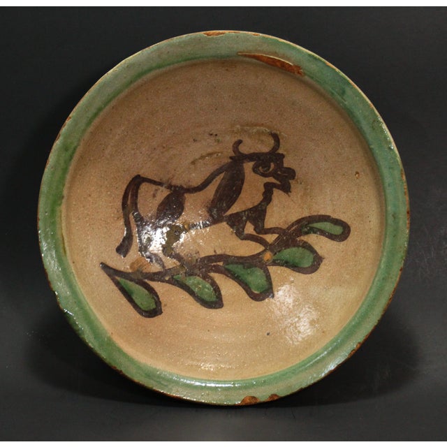 An amazing wheel thrown earthenware / redware bowl Grey glazed interior with primitively painted by hand brown bull in the...