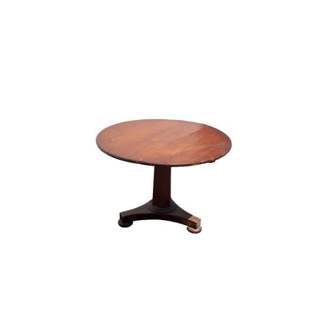 A classic 19th-century American Empire round center table in warm mahogany. Featuring a round top supported by a sturdy...